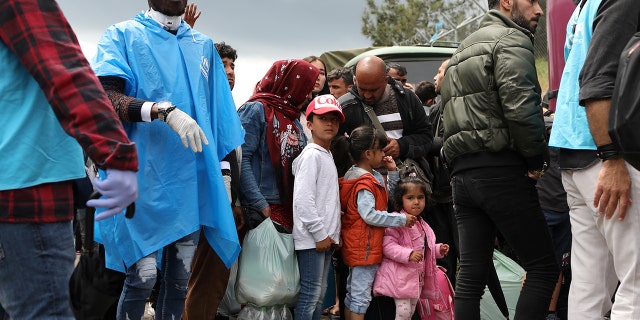 Migrants from the Moria camp wait to board busses to the port, from where they will be transferred to the mainland as a precaution against the spread of the coronavirus disease (COVID-19) outbreak, on the island of Lesbos, Greece, May 3, 2020. REUTERS/Elias Marcou - RC21HG917AWW