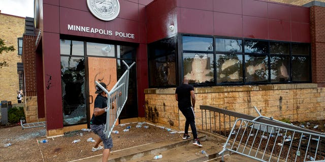 Protesters damage properties at the Minneapolis 3rd Police Precinct in Minneapolis on May 27. The mayor of Minneapolis called Wednesday for criminal charges against the white police officer seen on video kneeling against the neck of a handcuffed black man who complained that he could not breathe and died in police custody. (Carlos Gonzalez/Star Tribune via AP)