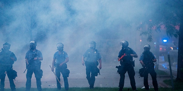 Police officers deploy to disperse protesters gathered for George Floyd in Minneapolis on Tuesday, May 26, 2020. Four Minneapolis officers involved in the arrest of the black man who died in police custody were fired Tuesday, hours after a bystander’s video showed an officer kneeling on the handcuffed man’s neck, even after he pleaded that he could not breathe and stopped moving. (Richard Tsong-Taatarii/Star Tribune via AP)