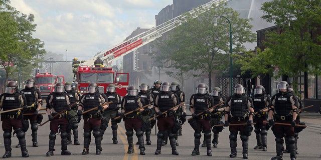 Minnesota state troopers provide protection as firefighters battle a fire, May 29, after another night of protests, fires and looting over the arrest of George Floyd. (AP Photo/Jim Mone)