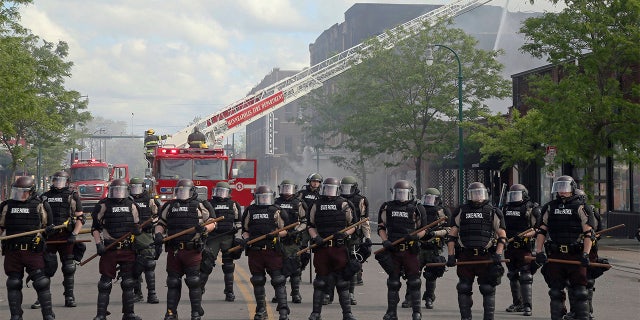 Minnesota state troopers provide protection as firefighters battle a fire, May 29, after another night of protests, fires and looting over the arrest of George Floyd. (AP Photo/Jim Mone)