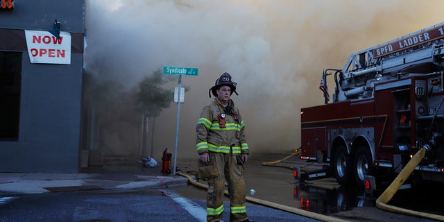 A firefighter pauses on Thursday, May 28, 2020, the third straight day of protests in St. Paul, Minn. (AP Photo/Julio Cortez)