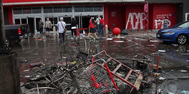 Debris and carts are strewn in the Target parking lot near the Minneapolis Police Third Precinct, Thursday, May 28, 2020,  following a night of rioting and looting as protests continue over the arrest of George Floyd who died in police custody.