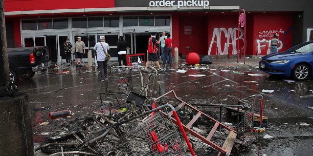 Debris and carts are strewn in the Target parking lot near the Minneapolis Police Third Precinct, Thursday, May 28, 2020, following a night of rioting and looting as protests continue over the arrest of George Floyd who died in police custody.