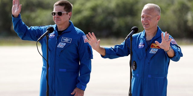 Métis - NASA astronauts Bob Behnken, left, and Doug Hurley wave as they leave a news conference after they arrived at the Kennedy Space Center in Cape Canaveral, Fla., Wednesday, May 20, 2020.
