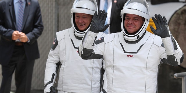 NASA astronauts Bob Behnken (R) and Doug Hurley (L) walk out of the Operations and Checkout Building on their way to the SpaceX Falcon 9 rocket with the Crew Dragon spacecraft on launch pad 39A at the Kennedy Space Center on May 27, 2020 in Cape Canaveral, Florida.