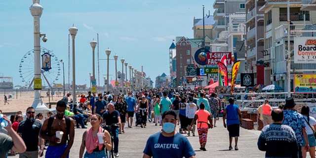 People enjoy the boardwalk during the Memorial Day holiday weekend amid the coronavirus pandemic on May 23, 2020, in Ocean City, Maryland. (Photo by ALEX EDELMAN/AFP via Getty Images)