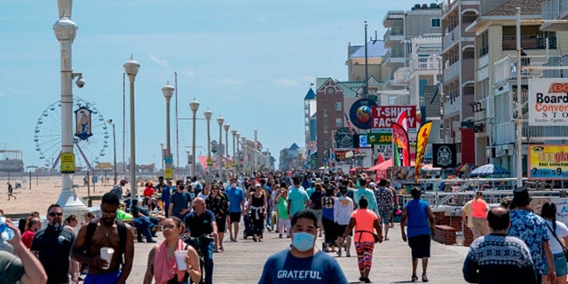 People enjoy the boardwalk during the Memorial Day holiday weekend amid the coronavirus pandemic on May 23, 2020, in Ocean City, Maryland. (Photo by ALEX EDELMAN/AFP via Getty Images)