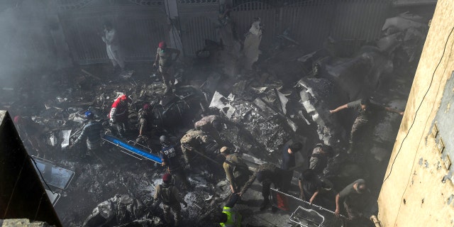 Rescue workers search for victims at the site after a Pakistan International Airlines aircraft crashed at a residential area in Karachi on May 22, 2020.