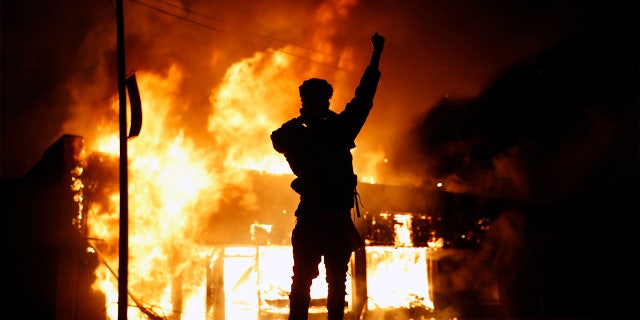 A check-cashing business burns during protests in Minneapolis on May 29, 2020. Protests continued following the death of George Floyd, who died in police custody in Minneapolis on Memorial Day. (AP Photo/John Minchillo)