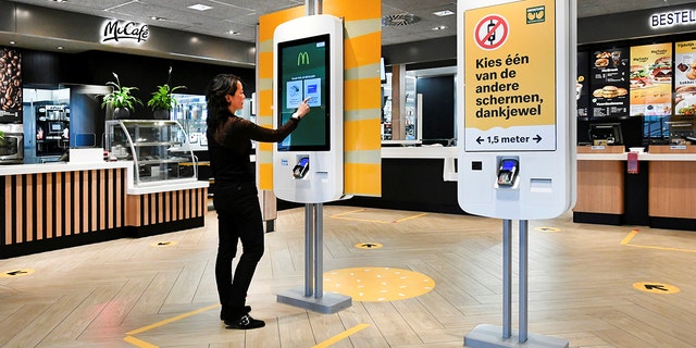 A woman uses a touch screen at a prototype location of fast-food giant McDonald's for restaurants which respect the 1.5m social distancing measure, amid the coronavirus disease (COVID-19) outbreak, in Arnhem, Netherlands, May 1, 2020.