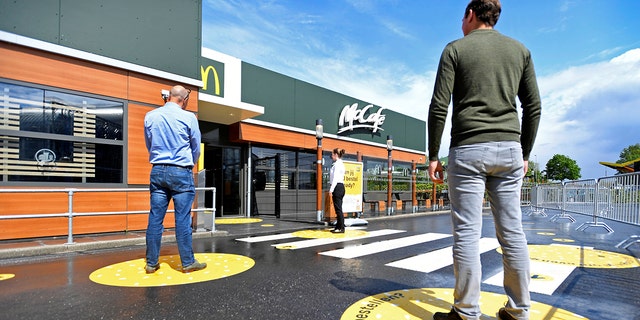 Customers waiting outside on social-distancing markings at a prototype location of fast-food giant McDonald's for restaurants which respect the 1.5m social distancing measure, amid the coronavirus disease (COVID-19) outbreak, in Arnhem, Netherlands.