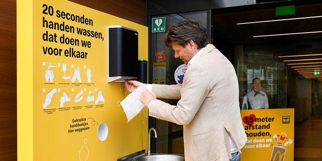 A customer cleans his hands before entering a prototype location of fast-food giant McDonald's for restaurants which respect the 1.5m social distancing measure, amid the coronavirus disease (COVID-19) outbreak, in Arnhem, Netherlands, May 1, 2020.