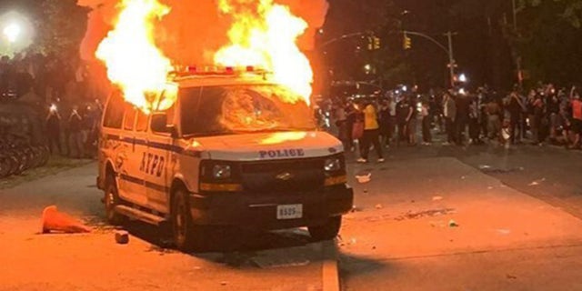 A New York Police Department vehicle is set on fire as people from around the country protest the death of George Floyd in New York, May 29, 2020.