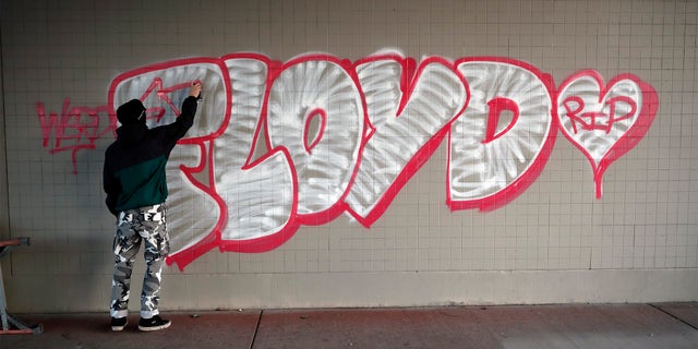 A protester spray paints George Floyd's name Friday, May 29, 2020, in Minneapolis. (Associated Press)