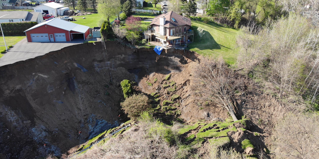 Drone footage shows a landslide in New York on Sunday that forced the evacuation of several residents and left homes dangling on the edge of a cliff.