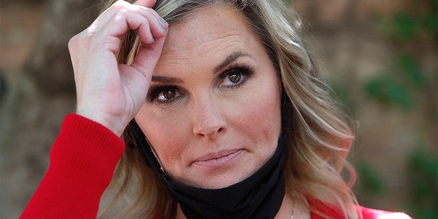 Salon owner Shelley Luther adjusts her hair while listening to a question after she was cited by City of Dallas officials for reopening her Salon A la Mode in Dallas, Friday, April 24, 2020. Hair salons have not been cleared for reopening in Texas. Luther was asked by officials to close and was issued a citation when she refused. Luther said she will remain open for business. (AP Photo/LM Otero)