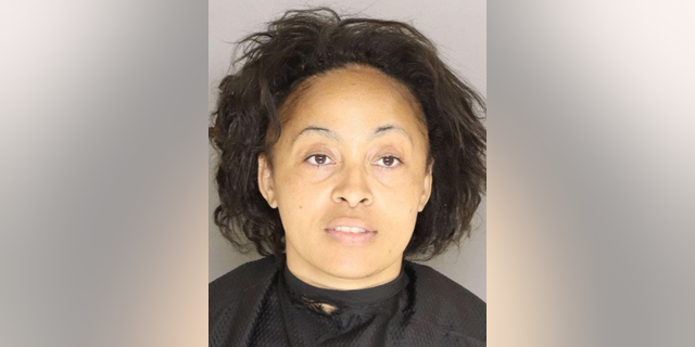 Shenir Gibson Holliday, 38, was taken into custody after police reviewed video footage inside a supermarket that showed her licking her hands and coughing before pulling on freezer doors and touching food items.