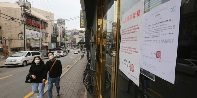 Notices of the Seoul city emergency administrative order to prohibit gathering are posted at the entrance of a temporarily closed dance club in Seoul, South Korea, Sunday, May 10, 2020.