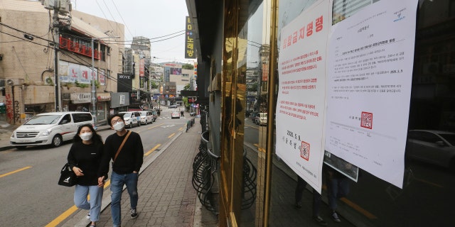 Notices of the Seoul city emergency administrative order to prohibit gathering are posted at the entrance of a temporarily closed dance club in Seoul, South Korea, Sunday, May 10, 2020.