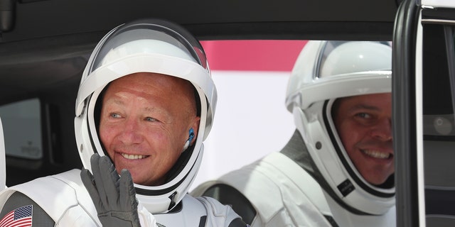 NASA astronauts Bob Behnken (R) and Doug Hurley sit in a Tesla vehicle after walking out of the Operations and Checkout Building on their way to the SpaceX Falcon 9 rocket with the Crew Dragon spacecraft on launch pad 39A at the Kennedy Space Center on May 30, 2020 in Cape Canaveral, Florida.