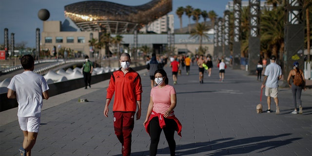 People walk along a seafront promenade in Barcelona, Spain, Saturday, May 2, 2020. Spaniards have filled the streets of the country to do exercise for the first time after seven weeks of confinement in their homes to fight the coronavirus pandemic. People ran, walked, or rode bicycles under a brilliant sunny sky in Barcelona on Saturday, where many flocked to the maritime promenade to get as close as possible to the still off-limits beach. People are supposed to respect a 1-measure distance, but the crowds in some spots made that impossible. 