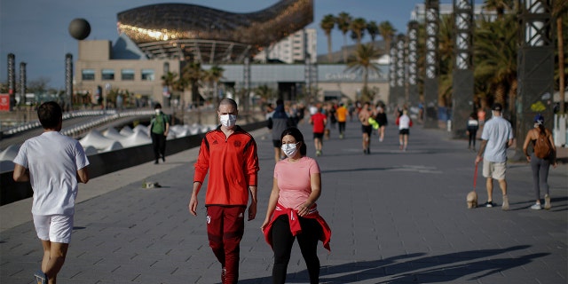 People walk along a seafront promenade in Barcelona, Spain, Saturday, May 2, 2020. Spaniards have filled the streets of the country to do exercise for the first time after seven weeks of confinement in their homes to fight the coronavirus pandemic. People ran, walked, or rode bicycles under a brilliant sunny sky in Barcelona on Saturday, where many flocked to the maritime promenade to get as close as possible to the still off-limits beach. People are supposed to respect a 1-measure distance, but the crowds in some spots made that impossible.