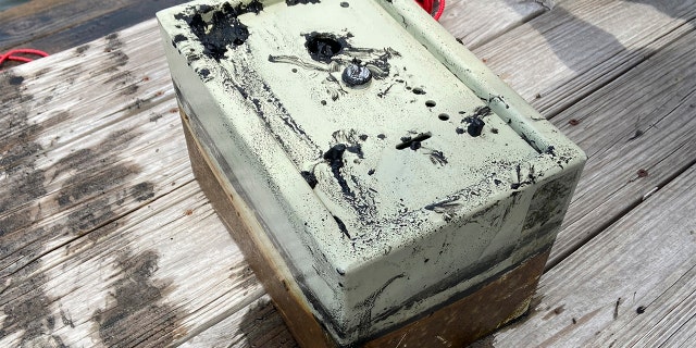 In this May 9, 2020, photo provided by Catherine Brewer, is a safe that Knox Brewer pulled out of Whitney Lake in South Carolina. The 6-year-old was using a magnet attached to a string to fish for metal in the water when he reeled in a lockbox that police said was stolen from a woman who lived nearby eight years ago. (Catherine Brewer via AP)