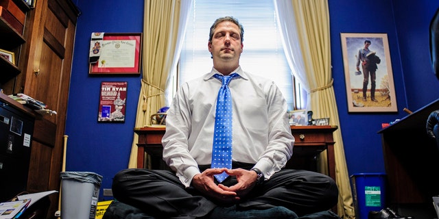 Representative Tim Ryan meditates in his office. 