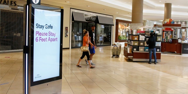 Signage encourages social distancing as Penn Square Mall reopens to the public Friday, May 1, 2020, in Oklahoma City. The mall has been closed since mid-March due to coronavirus concerns.