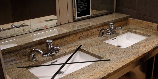 Alternating sinks in the restroom at Penn Square mall are taped off to promote social distancing as the mall reopens Friday, May 1, 2020, in Oklahoma City. The mall has closed one of two restrooms and five of seven entrances. The mall has been closed since mid-March due to coronavirus concerns. 