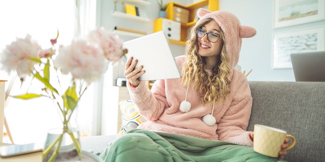 A young woman is shown on the couch at home. Some young people are expressing a nostalgia for the lockdown era. Fox News Digital spoke to experts about these sentiments. (iStock)