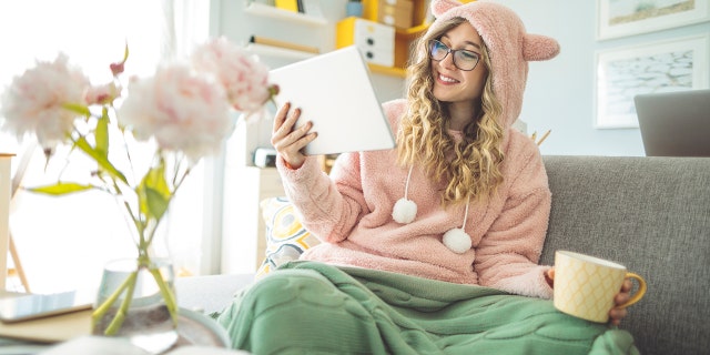 A young woman is shown on the couch at home. Some young people are expressing a nostalgia for the lockdown era. Fox News Digital spoke to experts about these sentiments. (iStock)