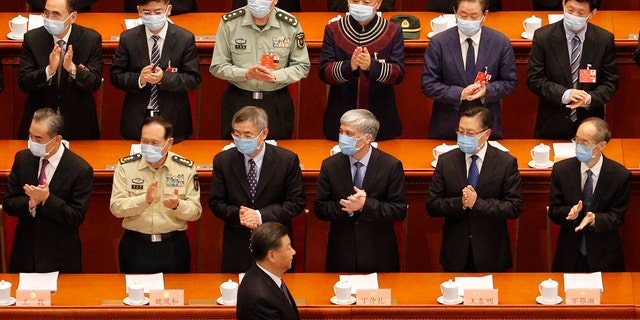 Delegates wearing face masks to protect against the spread of the new coronavirus applaud as Chinese President Xi Jinping arrives during the opening session of the Chinese People's Political Consultative Conference (CPPCC) at the Great Hall of the People in Beijing, Thursday, May 21, 2020. (AP Photo/Andy Wong, Pool)
