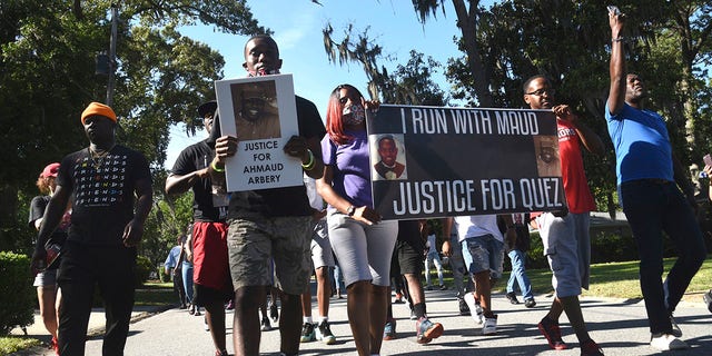 In this Tuesday, May 5, 2020, photo, a crowd marches through a neighborhood in Brunswick, Ga. They were demanding answers in the death of Ahmaud Arbery. An outcry over the Feb. 23 shooting of Arbery has intensified after cellphone video that lawyers for Arbery's family say shows him being shot to death by two white men. (Bobby Haven/The Brunswick News via AP)
