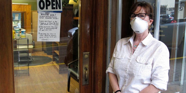 Barber Rhonda Adams poses outside her shop shop in downtown Juneau, Alaska, on April 24 after some businesses were allowed to reopen. Adams said she was excited to get back to work. (AP Photo/Becky Bohrer)