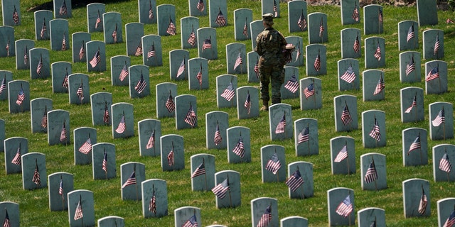 An Old Guard takes part in "Flags-In", an annual event where a small American flag is placed in front of more than 240,000 headstones of U.S. service members buried at Arlington National Cemetery in Arlington, Virginia, U.S., May 23, 2019. (Reuters)