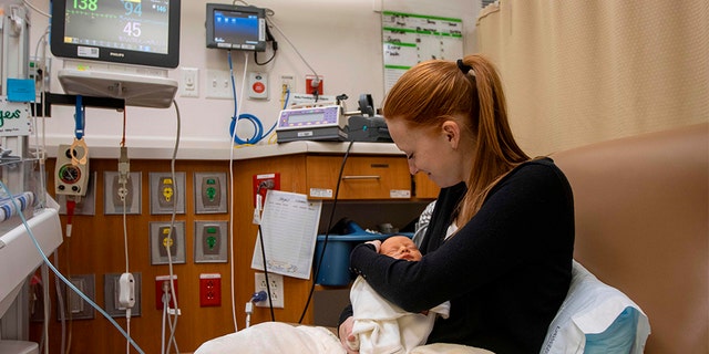 Jenny Collins holds her infant son Hayes, born two weeks early in the Neonatal Intensive Care Unit(NICU) at the Intermountain Healthcare's American Fork Hospital on December 16, 2019 in American Fork, Utah. (Photo by Natalie BEHRING / AFP) (Photo by NATALIE BEHRING/AFP via Getty Images)