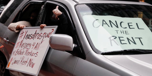 A sign with the message to "CANCEL THE RENT" is displayed in a vehicle windshield as a caravan of May Day protesters drives up 2nd Avenue outside the offices of New York Gov. Andrew Cuomo, on Friday. (AP)