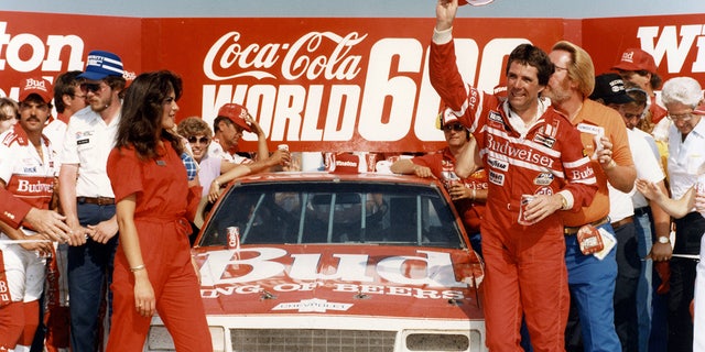 CHARLOTTE, NC — May 26, 1985: Darrell Waltrip waves his cap in victory lane at Charlotte Motor Speedway after winning the Coca-Cola World 600 NASCAR Cup race, one of three Cup victories Waltrip had during the year on his way to a third NASCAR Cup championship. (Photo by ISC Images &amp; Archives via Getty Images)