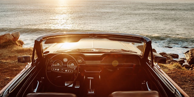 Shot of an empty vintage car parked along the coast at sunset