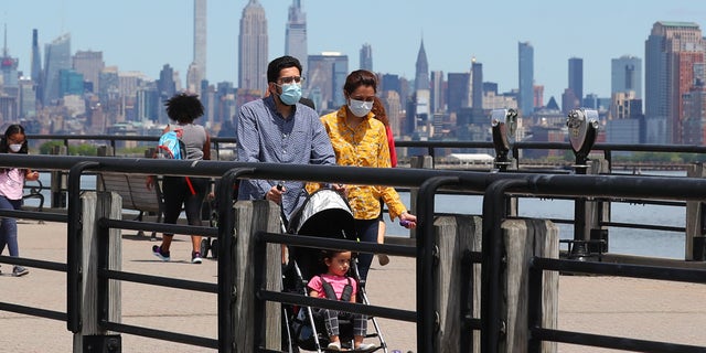 A general view of people wearing masks walking on the promenade as New Jersey continues with its Phase 1 of reopening the state during the Coronavirus (COVID-19) pandemic on May 16, 2020, at Liberty State Park in Jersey City, NJ.