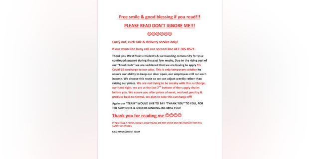 Billy Yuzar posted this notice on the door and register of his restaurant, to inform his customers of the surcharge.