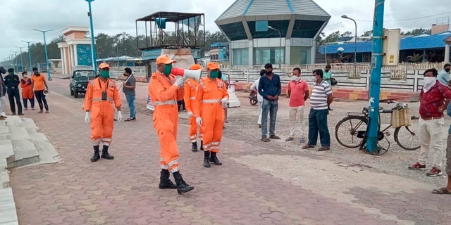 This photograph provided by India's National Disaster Response Force (NDRF) force shows NDRF personal making announcements to warn people on the Bay of Bengal coast about Cyclone Amphan at Namkhana, South 24 Parganas, West Bengal, India.