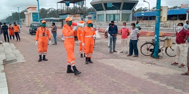 This photograph provided by India's National Disaster Response Force (NDRF) force shows NDRF personal making announcements to warn people on the Bay of Bengal coast about Cyclone Amphan at Namkhana, South 24 Parganas, West Bengal, India.