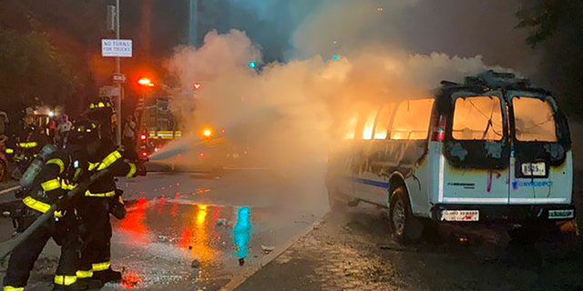 In this photo provided by Khadijah, firefighters work to contain the flames from a New York City Police Department van ablaze, Friday, May 29, 2020, in the Brooklyn borough of New York, amid a protest of the death of George Floyd in police custody on Memorial Day in Minneapolis. (Khadijah via AP)