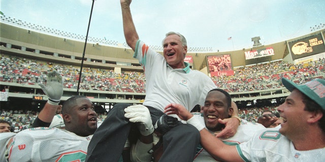 Miami Dolphins coach Don Shula is carried off the field by players Keith Sims (L) and Larry Webster (C) after Miami defeated Philadelphia 19-14 in Philadelphia November 14, 1993. This win made Shula the most successful coach in the league giving him his 325th career victory. (REUTERS/Gary Hershorn)