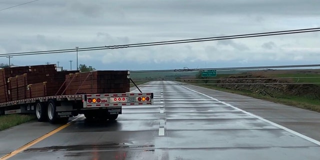 A semi-truck nearly hit power lines that were knocked down by a severe thunderstorm in Kansas on Monday.