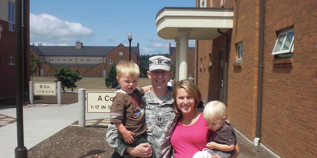 Army Captain John Hallett with his wife Lisa and their young children. 