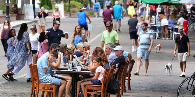 Visitors to Park Avenue in Winter Park, Fla., dine al fresco on the street as restaurants and shops reopened Saturday in the popular dining district under Phase One restrictions. (Joe Burbank/Orlando Sentinel via AP)
